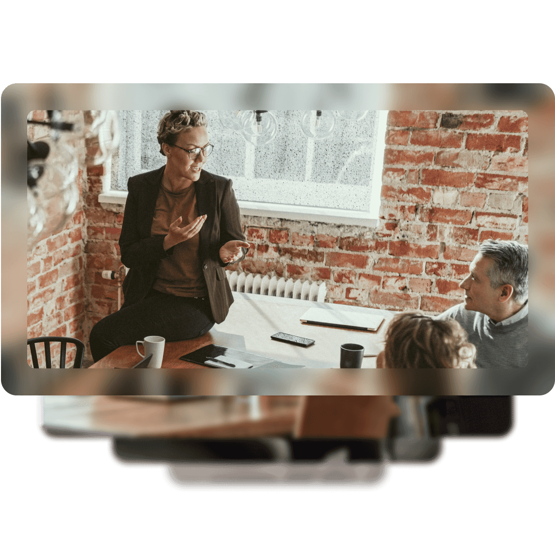 Image of a woman having a conversation with her coworkers at a table. 