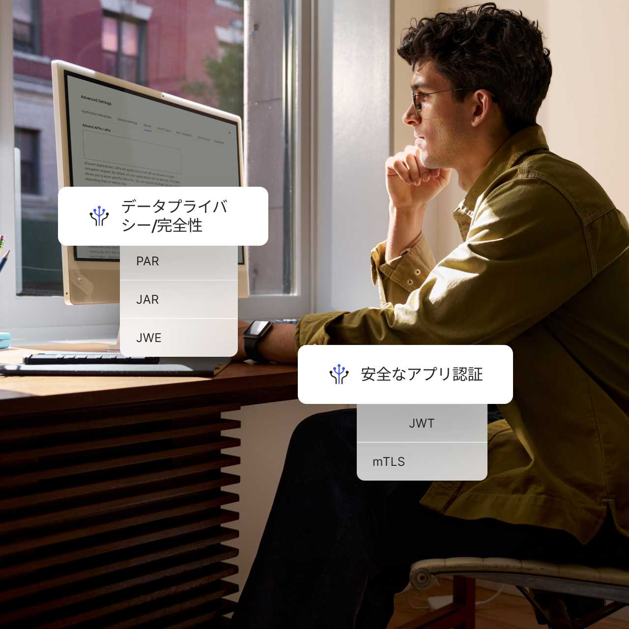The words Data Privacy and Integrity and Secure App Authentication overlaying an image of a man working on desktop computer.
