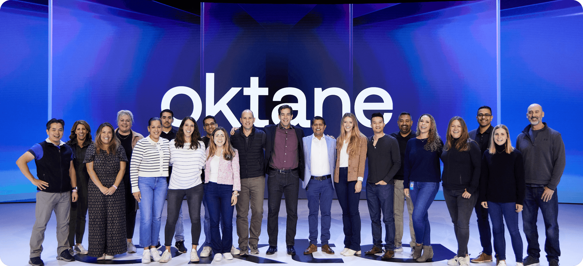 Group of colleagues posing with Okta CEO at Oktane