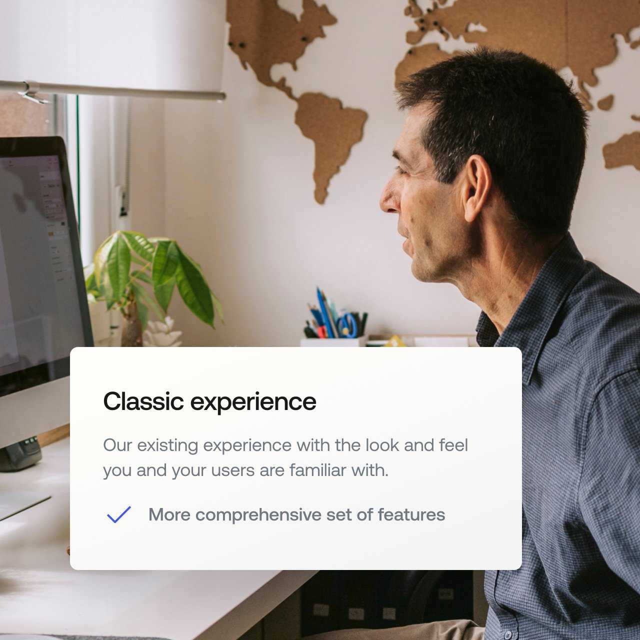 A man sits on his desktop in front of a map of the world with a pop out bubble describing the “classic experience”