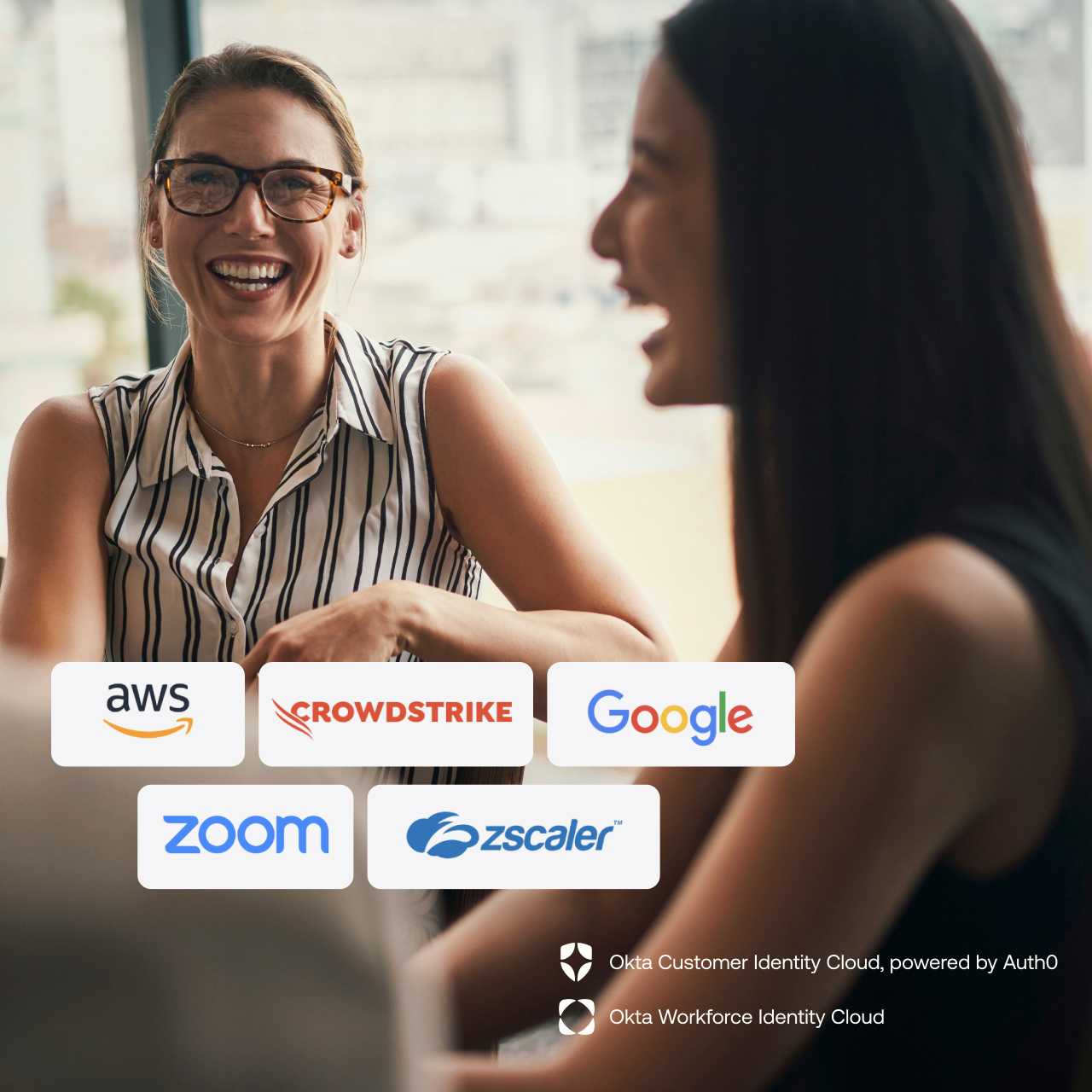 Two women sitting and laughing with each other with company logos transposed on top of photo