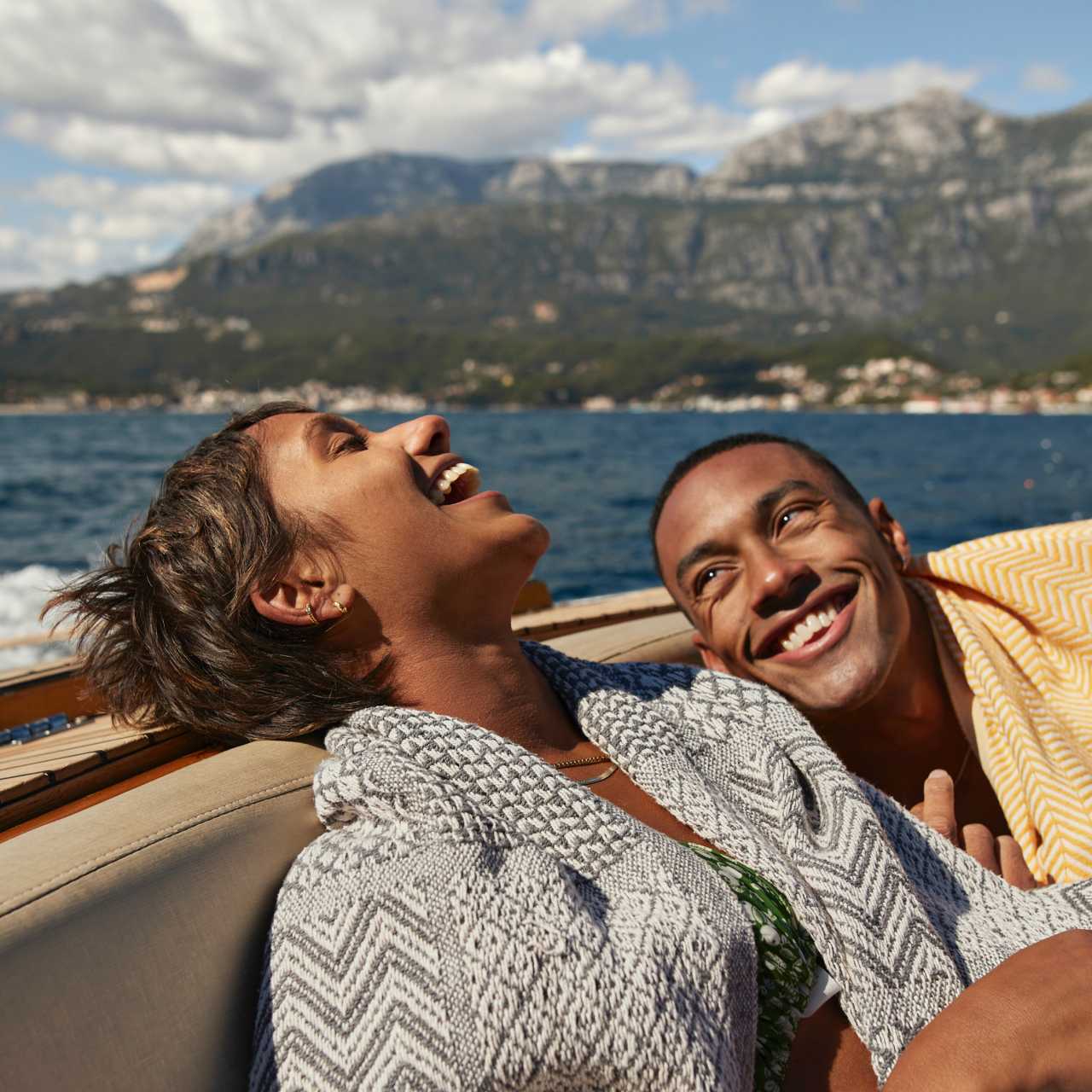 Woman and man sitting on a boat on a lake laughing 