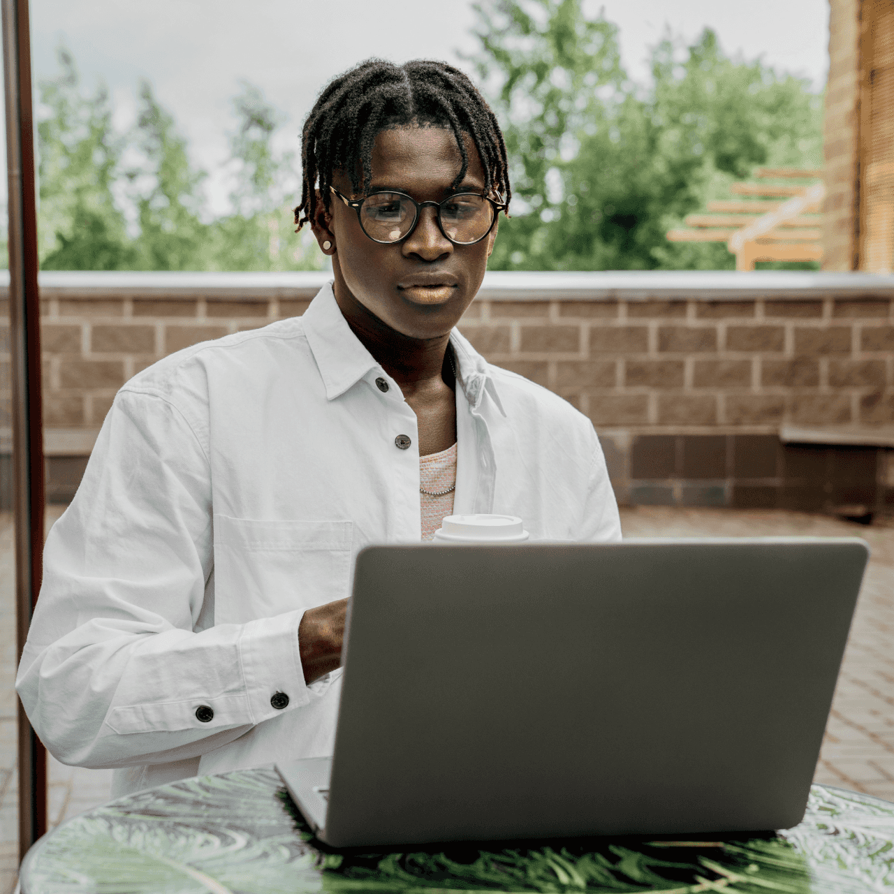 Image of man sitting at the computer with a cup of coffee.