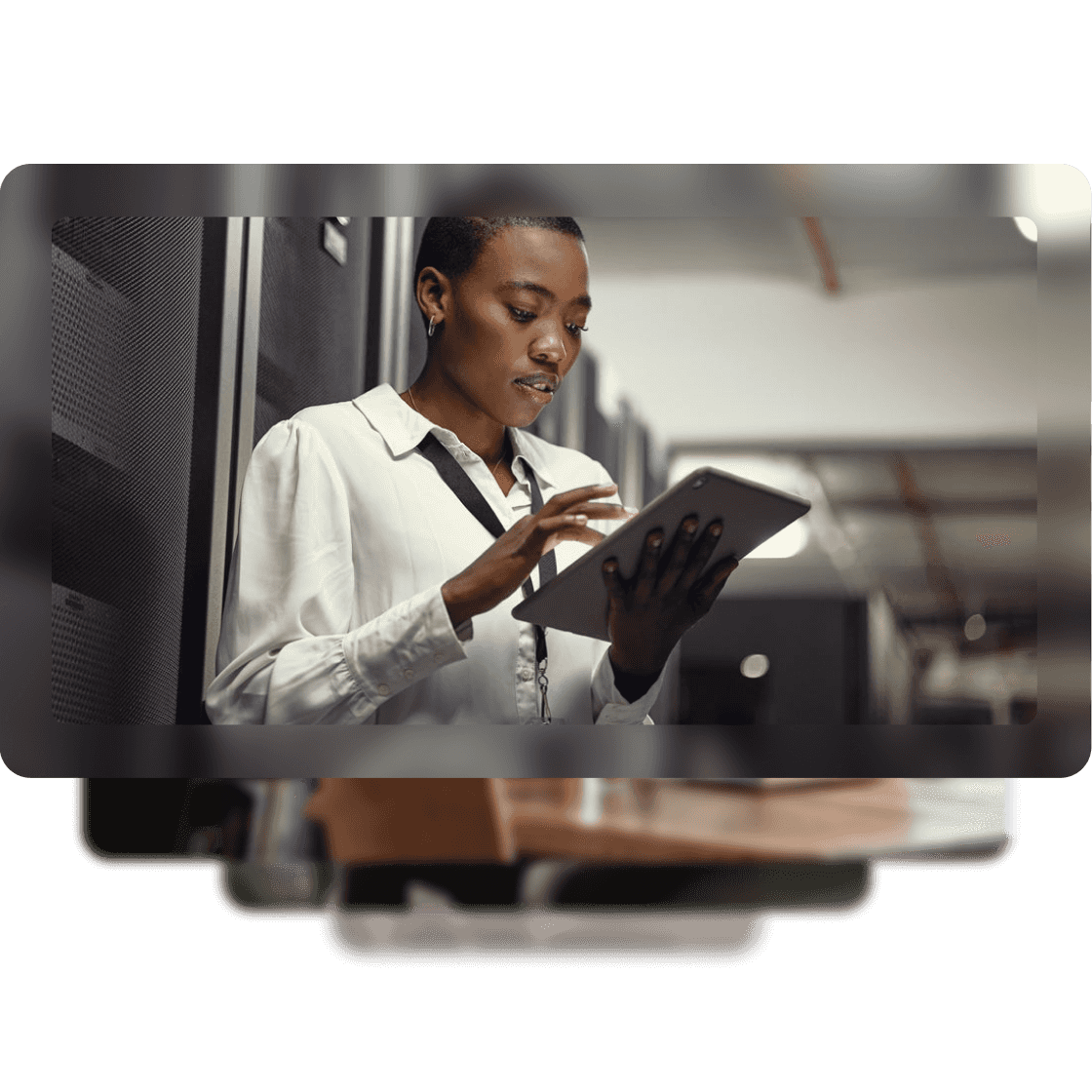 An image of a woman wearing a white blouse and a lanyard on a tablet in an office.