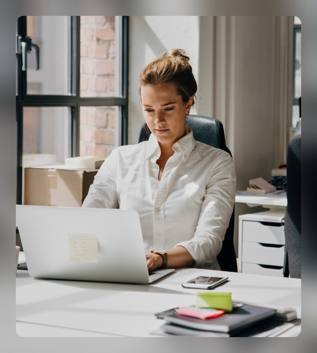 A young woman sitting in the office and working on her laptop