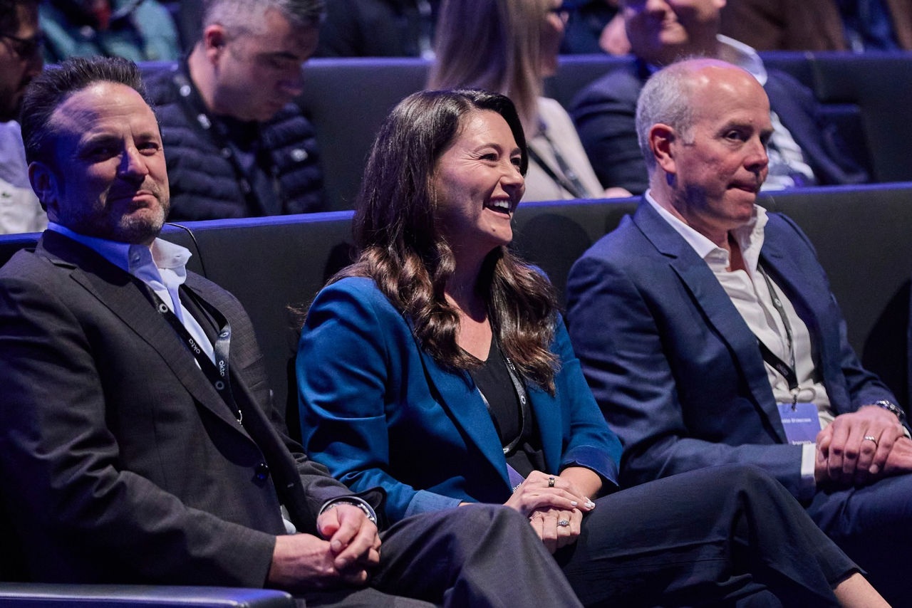 A view from the back of an auditorium showing engaged audience members watching a keynote presentation at the Okta conference.