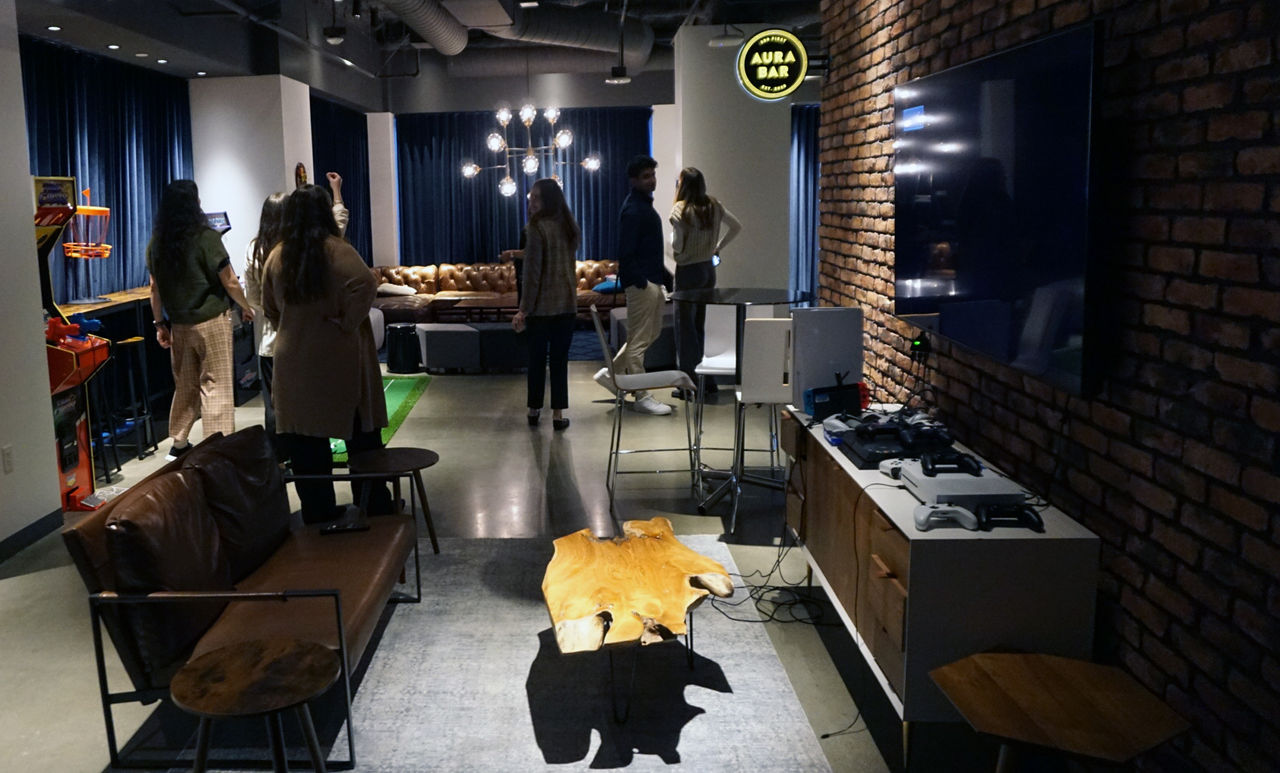 A contemporary lounge featuring a gaming setup with consoles and controllers on a wooden cabinet.                   