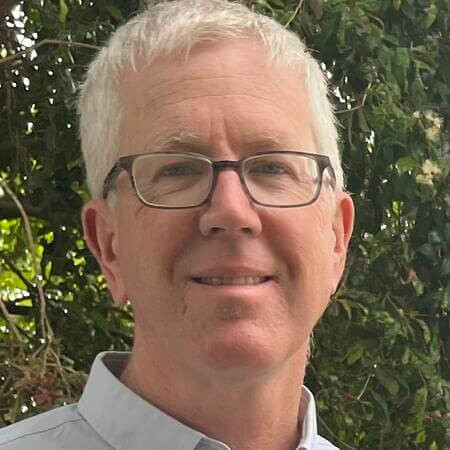 Francis Kelly, a white man with gray hair and glasses, smiles